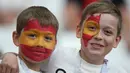 Dua bocah mengecat wajahnya dengan warna bendera Spanyol ketika menyaksikan pertandingan Grup B Piala Dunia 2018 melawan Iran di Kazan Arena, Rusia, 20 Juni 2018. (AFP PHOTO / Roman Kruchinin)