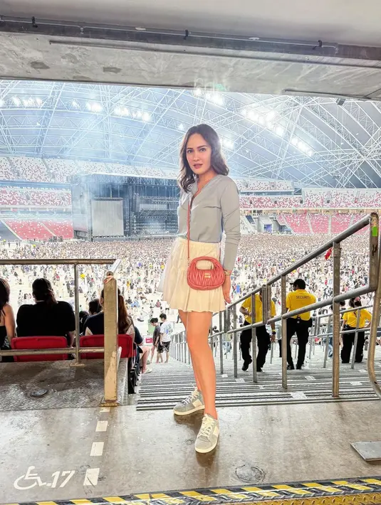 Tak kalah memesona penampilan Shandy Aulia saat nonton konser. Ibu satu anak itu tampil fresh dan manis dengan padu padan long sleeve top biru pastel, mini skirt putih, sneakers, dan sling bag warna pink. [@shandyaulia].