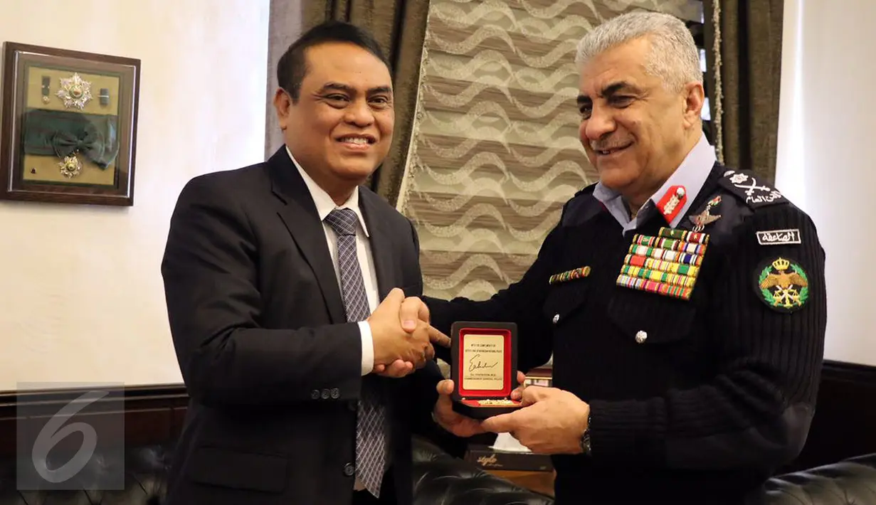 Wakapolri Komjen Pol Syafruddin bertukar cinderamata dengan Kepala Public Security Departement (PSD) Kerajaan Jordania Mayor Jenderal Ahmad Sarhan Al Faqih saat kunjungan kerja di Jordania, Rabu (18/1). (Liputan6.com)