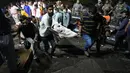 Relawan dan petugas kesehatan membawa korban setelah jembatan kabel di seberang sungai Machchu runtuh di kota Morbi, negara bagian Gujarat, India, Senin, 31 Oktober 2022. Puluhan orang tewas dan banyak yang dikhawatirkan terluka dalam kecelakaan itu. (AP/Ajit Solanki)