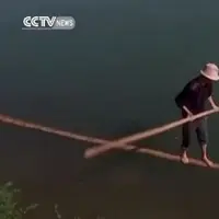 Ternyata pengendali air itu benar-benar ada. Seorang bapak terlihat melintasi sungai berarus sedang cuma dengan sebatang bambu!