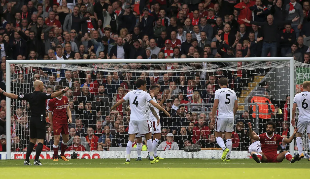Mohamed Salah (2kanan) melakukan protes kepada wasit, Roger East (kiri) saat laga Liverpool melawan Burnley pada lanjutan Premier League pekan kelima di Anfield Stadium, Liverpool (16/9/2017). Liverpool bermain imbang 1-1. (Peter Byrne/PA via AP)