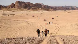 Para wisatawan berjalan melalui daerah Wadi Hudra dekat Ras Ghazala, Sinai Selatan, Mesir, (20/11). Kunjungan ini diikuti oleh 100 orang yang melakukan perjalanan hingga 25 km   . (REUTERS/Asmaa Waguih)