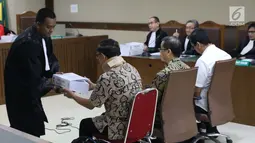 Terdakwa suap anggota DPRD Kalteng, Edy Saputra Suradja (kiri) menerima surat tuntutan dari JPU KPK usai dibacakan pada sidang di Pengadilan Tipikor, Jakarta, (27/2). Edy Saputra Suradja dituntut 2 tahun 6 bulan penjara. (Liputan6.com/Helmi Fithriansyah)