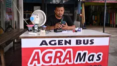 Seorang pria menggunakan kipas angin untuk mendinginkan dirinya saat bekerja di luar ruangan di Jakarta pada 7 Mei 2024. (ADEK BERRY / AFP)