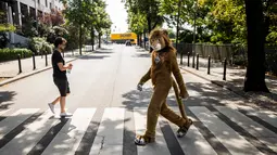 Peserta mengenakan kostum singa melintas di jalan saat parade konvensi Eurofurence di Berlin, Jerman (17/8). Dalam acara peserta mengenakan kostum hewan berbulu. (AFP Photo/Ganjil Andersen)