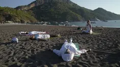 Orang-orang berlatih yoga di pantai di Adrasan, barat Antalya, Turki (24/9/2021). Orang-orang menikmati cuaca hangat di wilayah Mediterania saat salju pertama menyelimuti pegunungan tinggi di timur laut Turki. (AP Photo/Burhan Ozbilici)
