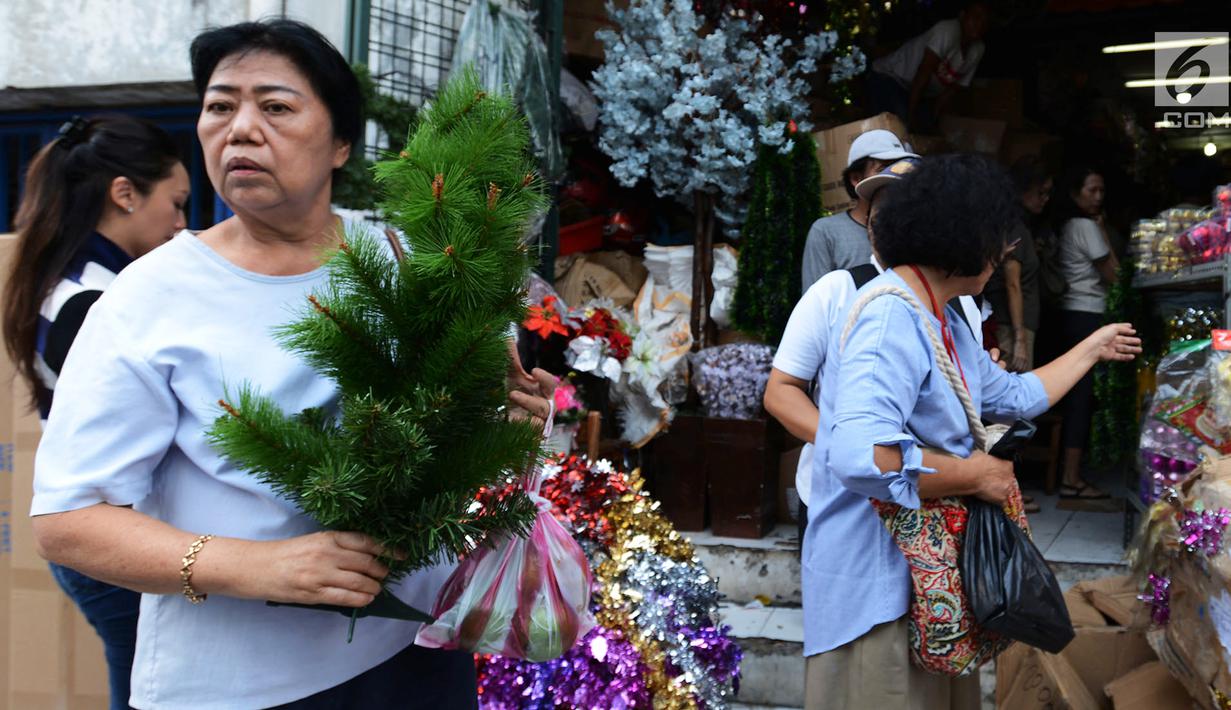 Pembeli memilih pernak-pernik perayaan Natal di Pasar Asemka, Jakarta,Kamis (13/12). Pedagang mengaku penjualan pernak-pernik Natal meningkat dari minggu sebeumnya. (Merdeka.com/Imam Buhori)