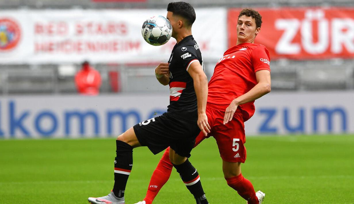 Pemain Bayern Munchen, Benjamin Pavard, berebut bola dengan pemain Fortuna Duesseldorf, Erik Thommy, pada laga Bundesliga di Allianz Arena, Sabtu (30/5/2020). Bayern Munchen menang 5-0 atas Fortuna Duesseldorf. (AP/Christof Stache)
