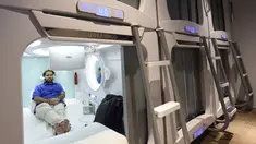 Seorang pengunjung menonton televisi di dalam Hotel Urbanpod di Mumbai, India (14/4). Kapsul hotel di Mumbai ini adalah yang pertama di India. (AFP/Indranil Mukherjee)