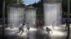 Anak-anak mendinginkan diri di air mancur umum di Vilnius, Lithuania, 26 Juni 2022. Gelombang panas berlanjut di Lithuania saat suhu naik hingga 32 derajat Celcius (89,6 derajat Fahrenheit). (AP Photo/Mindaugas Kulbis)