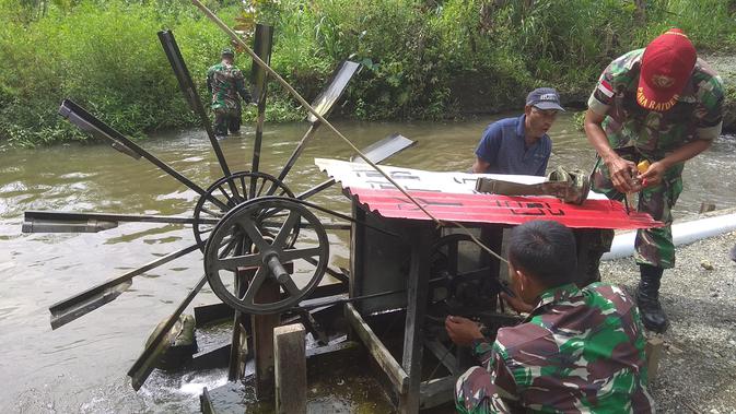 Perawatan kincir air di Kampung Kriku yang membuat adanya energi terbarukan untuk sumber listrik. (Liputan6.com/Katharina Janur)