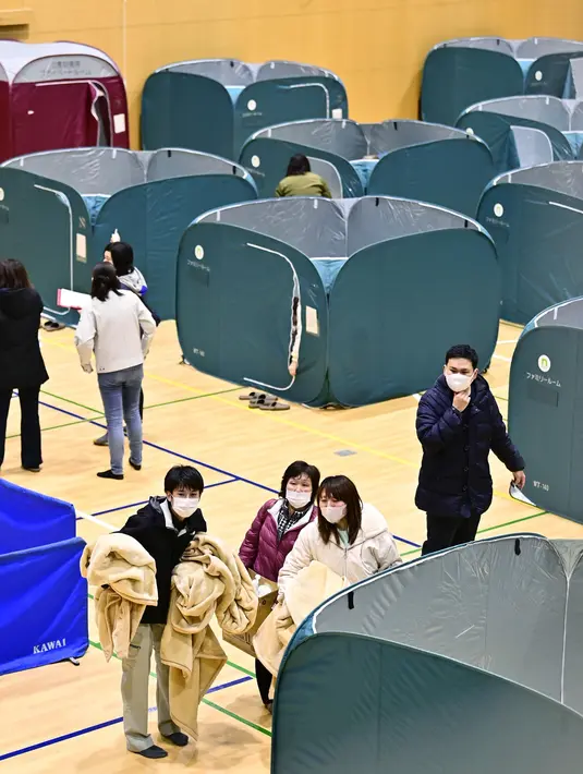 Pengungsi berlindung di gym saat gempa melanda daerah itu, di Soma, prefektur Fukushima, timur laut Jepang, Minggu (14/2/2021).  Getaran gempa terasa hingga Tokyo. (Kyodo News via AP)