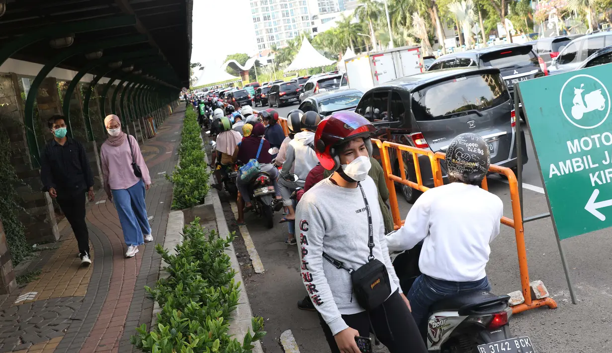 Warga bersama kendaraan antre memasuki kawasan Taman Impian Jaya Ancol, Jalarta, Kamis (29/10/2020). Selain tingginya minat warga berwisata di masa libur panjang, antrean ini juga disebabkan pengalihan buka tutup pintu masuk kawasan Taman Impian Jaya Ancol.  (Liputan6.com/Helmi Fithriansyah)