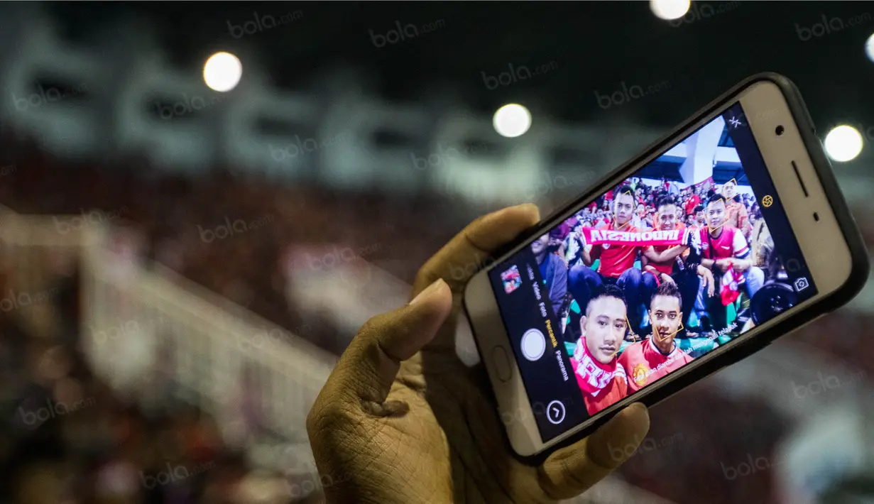 Suporter Timnas Indonesia selfie saat menonton laga semifinal Piala AFF 2016 melawan Vietnam di Stadion Pakansari, Jawa Barat, Sabtu (3/12/2016). (Bola.com/Vitalis Yogi Trisna)