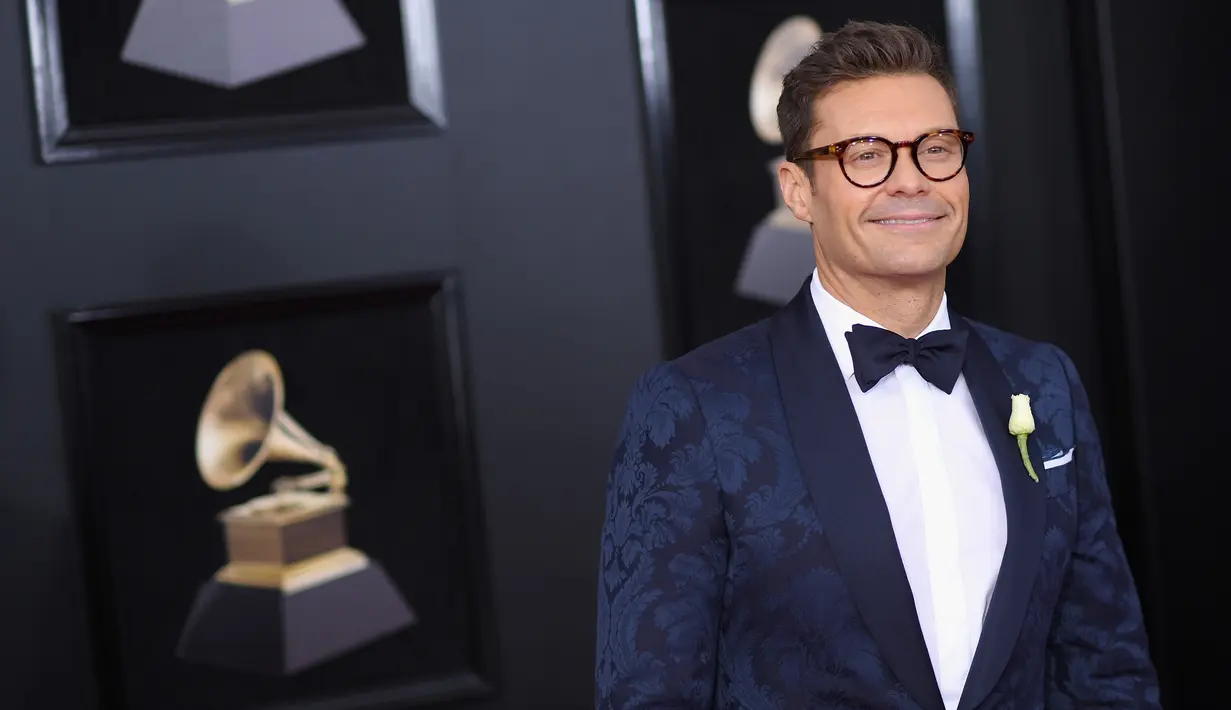 Pembawa acara Ryan Seacrest menyematkan mawar putih pada jasnya saat berjalan di karpet merah Grammy Awards 2018, New York, Minggu (28/1). Mereka memilih putih untuk mendukung MeToo, gerakan melawan pelecehan seksual (Dimitrios Kambouris/GETTY IMAGES/AFP)