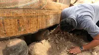 Menteri Purbakala Mesir Khaled el-Anany memeriksa 20 peti mati kuno terbuat dari kayu yang ditemukan di kota Luxor, 15 Oktober 2019. Kementerian menyebutkan penemuan ini merupakan "salah satu yang terbesar dan terpenting" dalam beberapa tahun terakhir. (Egyptian Ministry of Antiquities via AP)