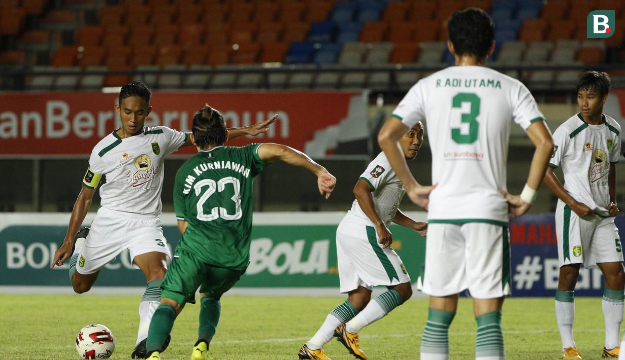 Gelandang PS Sleman, Kim Jeffrey Kurniawan (kedua dari kiri) berusaha menghadang tendangan bek Persebaya Surabaya, Rizky Ridho Ramadhani dalam laga Grup C Piala Menpora 2021 di Stadion Si Jalak Harupat, Bandung, Rabu (7/4/2021). PS Sleman menang 1-0 atas Persebaya. (Bola.com/Ikhwan Yanuar)