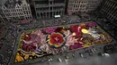 Para sukarelawan bekerja menempatkan bunga begonia ke dalam karpet bunga raksasa bertema Art Nouveau di Grand Place yang bersejarah di Brussels, Belgia, Kamis, 15 Agustus 2024. (AP Photo/Virginia Mayo)