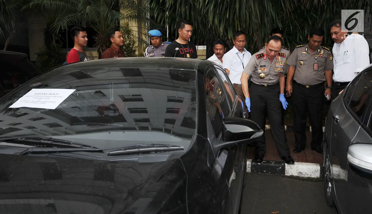 Kapolda Metro Jaya, Irjen Pol M Iriawan (ketiga kanan) melihat mobil yang digunakan tersangka kasus kekerasan usai rilis di Jakarta, Kamis (13/7). Polisi menangkap empat orang dan memburu satu tersangka lainnya. (Liputan6.com/Helmi Fithriansyah)