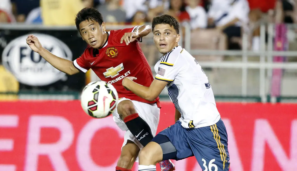 Gelandang Manchester United, Shinji Kagawa, mencoba melewati pemain Los Angeles Galaxy, Oscar Sorto, saat berlaga di Rose Bowl, Kalifornia, (23/7/2014). (REUTERS/Lucy Nicholson)