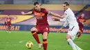 Penyerang AS Roma, Edin Dzeko, berebut bola dengan bek Torino, Lyanco Vojnovic, pada laga lanjutan Liga Italia di Stadion Olimpico, Jumat (18/12/2020) dini hari WIB. AS Roma menang 3-1 atas Torino. (AFP/Vincenzo Pinto)