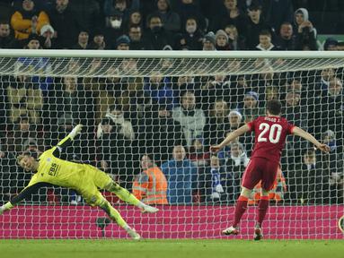 Penyerang Liverpool, Diogo Jota mencetak gol yang dijaga kiper Leicester City, Kasper Schmeichel pada adu penalti pertandingan perempat final Piala Liga Inggris di Stadion Anfield, Inggris, Kamis (22/12/2021). Liverpool menang adu penalti atas Leicester dengan skor 5-4. (AP Photo/Jon Super)