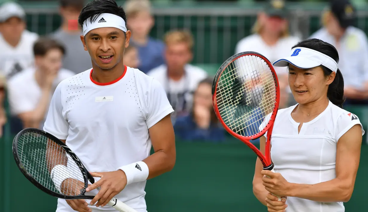 Petenis Indonesia Christopher Rungkat dan Shuko Aoyama dari Jepang bersiap melawan petenis Kroasia Nikola Mektic dan Alicja Rosolska dari Polandia pada putaran kedua ganda campuran Wimbledon 2019 di All England Lawn Tennis Club, Senin (8/7/2019). Christo/Aoyama kalah 5-7, 4-6. (GLYN KIRK/AFP)