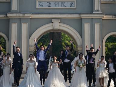 Para pasangan pengantin berpose bersama di Nanjing, Provinsi Jiangsu, China timur, pada 19 Mei 2020. Sebanyak 15 pasangan pengantin pada Selasa (19/5) berfoto bersama di Nanjing menjelang upacara pernikahan massal mereka yang dihelat pada 20 Mei. (Xinhua/Ji Chunpeng)