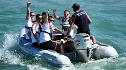Beberapa punggawa Timnas Jerman terlihat duduk di atas perahu motor menuju kapal di salah satu pantai dekat Santo Andre, Sao Paolo, Brasil, (10/6/2014). (AFP PHOTO/Markus Gilliar)