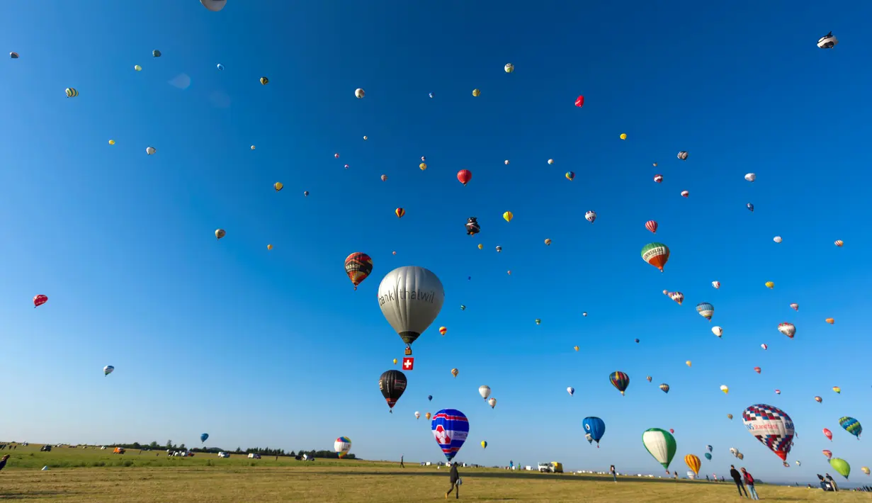 Ratusan balon udara terbang di pangkalan udara Chambley-Bussieres, Hagéville, Prancis, Senin (29/7/2019). Acara itu disebut sebagai salah satu festival balon udara terbesar di dunia. (Jean-Christophe VERHAEGEN/AFP)
