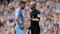 Wasit Anthony Taylor (kanan) berdiskusi dengan pemain Manchester City, Kevin De Bruyne saat pertandingan Liga Inggris antara Manchester City dan Liverpool, di Etihad Stadium, 10 April 2022. (AP/Jon Super)