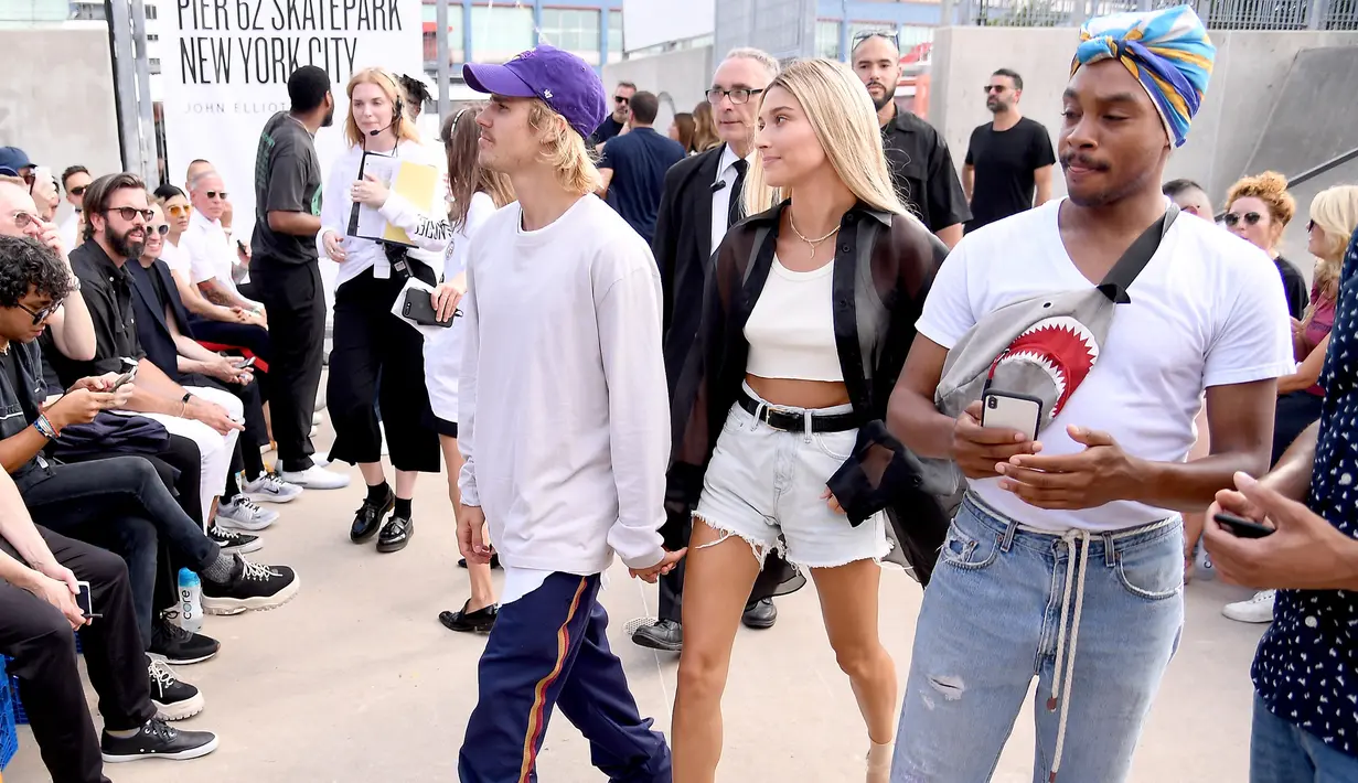 Justin Bieber dan Hailey Baldwin menghadiri fashion show John Elliot selama gelaran New York Fashion Week, 6 September 2018. Hailey Baldwin terlihat memesona dengan wig pirang panjang, potongan denim dan blus tipis. (Nicholas Hunt/Getty Images/AFP)