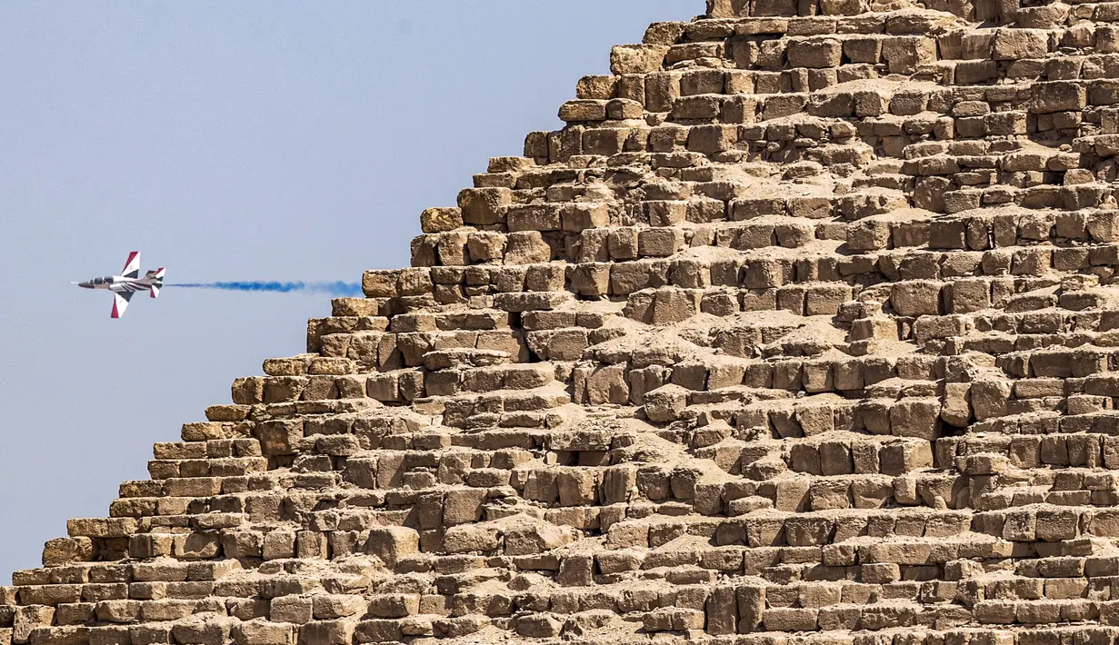 Sebuah pesawat K-8E Karakorum dari tim aerobatik "Silver Stars" Angkatan Udara Mesir tampil selama Pyramids Air Show 2022 di atas Giza Pyramids Necropolis,  Mesir, 3 Agustus 2022. (Mahmoud Khaled/AFP)