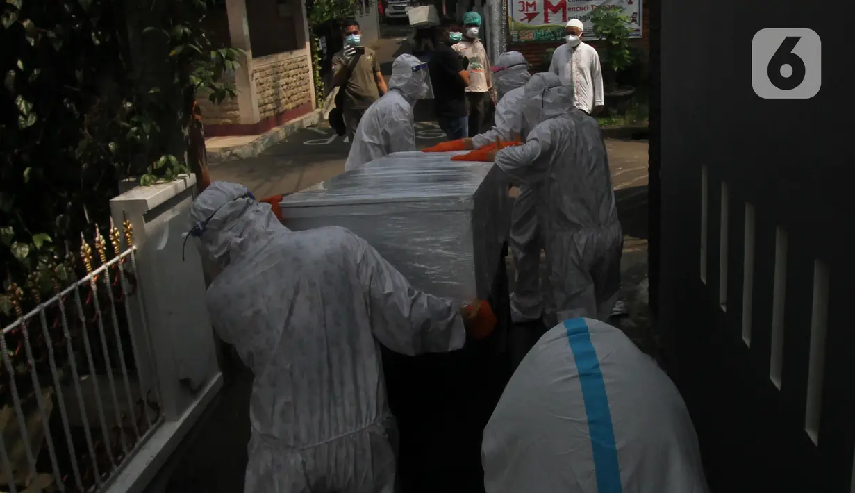 Petugas pemulasaraan jenazah Covid-19 membawa peti jenazah yang meninggal ketika menjalani isolasi mandiri di Kampung Gedong, Jakarta, Sabtu (10/7/2021). Proses pemulasaran jenazah dilakukan sesuai prokes Covid-19 dikarenakan hasil test swab korban positif. (merdeka.com/Imam Buhori)