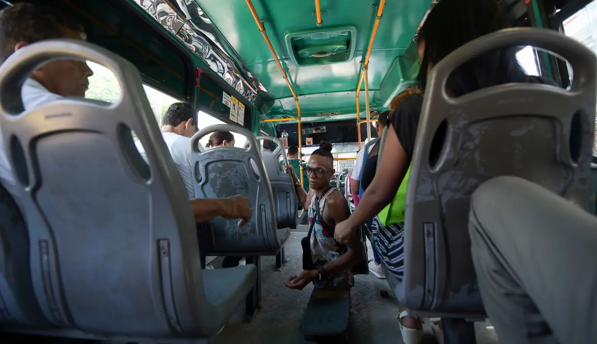Imigran Venezuela, Alfonso Mendoza alias Alca mengumpulkan uang usai mengamen di sebuah bus di Barranquilla, Kolombia, 28 September 2018. Saat ini, Alca menjadi contoh mengatasi kesulitan. (Raul ARBOLEDA/AFP)