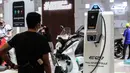 Pengunjung memperhatikan cara pengisian bahan bakar sepeda motor listrik yang dipamerkan pada pembukaan Indonesia Motorcycle Show (IMOS) 2022 di Jakarta Convention Center (JCC), Jakarta, Rabu (2/11/2022). Acara ini berlangsung pada tanggal 2 hingga 6 November 2022. (Liputan6.com/Johan Tallo)