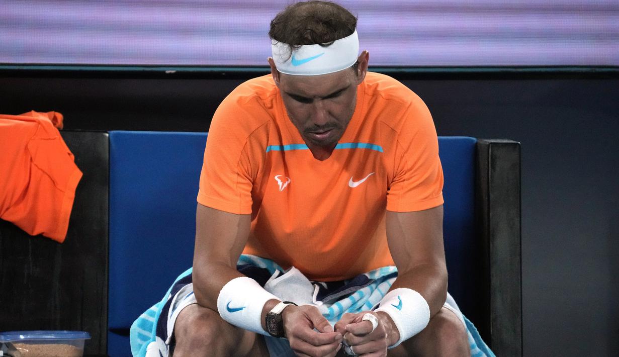 Petenis Spanyol, Rafael Nadal, tampak kecewa usai ditaklukkan petenis Amerika Serikat, Mackenzie McDonald, pada Australian Open 2023 di Melbourne Park, Rabu (18/1/2023). Nadal kalah 6-4, 6-4, 7-5 dari Mackenzie. (AP Photo/Dita Alangkara)