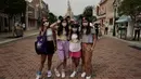 Pengunjung yang mengenakan masker berpose untuk foto di Disneyland Hong Kong pada Jumat (25/9/2020). Setelah dibuka dan tutup kembali, Disneyland Hong Kong dibuka kembali untuk wisatawan. (AP Photo/Kin Cheung)
