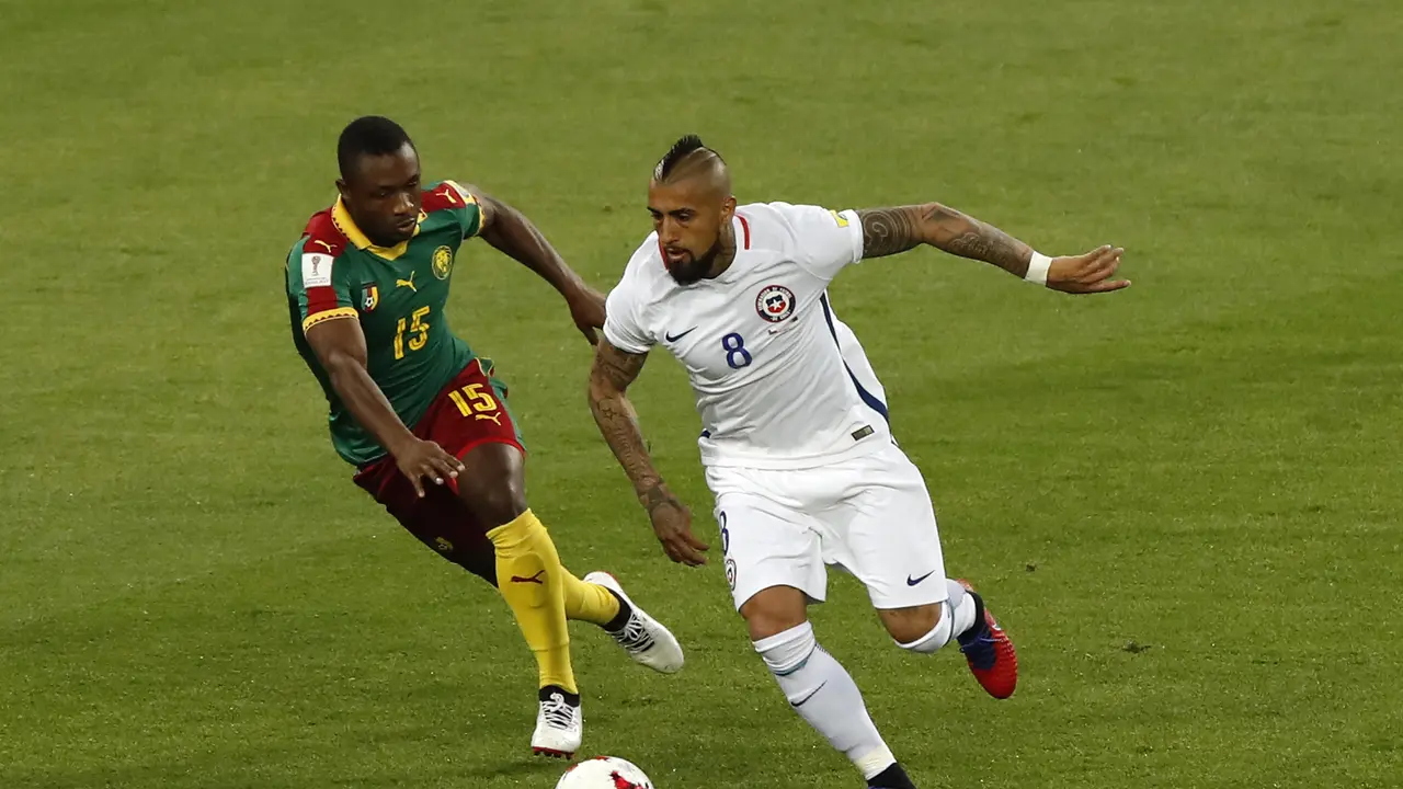 Gelandang Cile Arturo Vidal (kanan) berebut bola dengan pemain Kamerun Sebastien Siani di laga Piala Konfederasi 2017 (AP Photo/Alexander Zemlianichenko)