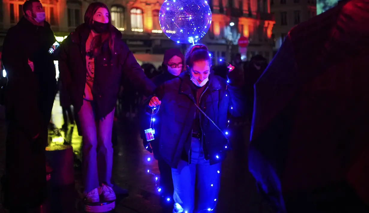 Orang-orang menghadiri pertunjukan cahaya malam di Lyon, Prancis tengah, Rabu (8/12/2021). Jutaan orang diperkirakan akan menghadiri acara Festival of Lights selama empat hari di kota itu. (AP Photo/Laurent Cipriani)