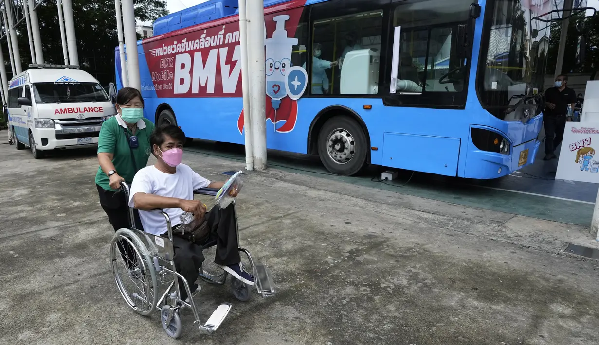 Petugas membantu seseorang dengan kursi roda setelah menerima vaksin COVID-19 dari unit vaksinasi keliling di Bangkok, Rabu (8/9/2021). Otoritas kesehatan Bangkok meluncurkan unit vaksinasi keliling pertama untuk mendukung kampanye vaksinasi di masyarakat. (AP Photo/Sakchai Lalit)