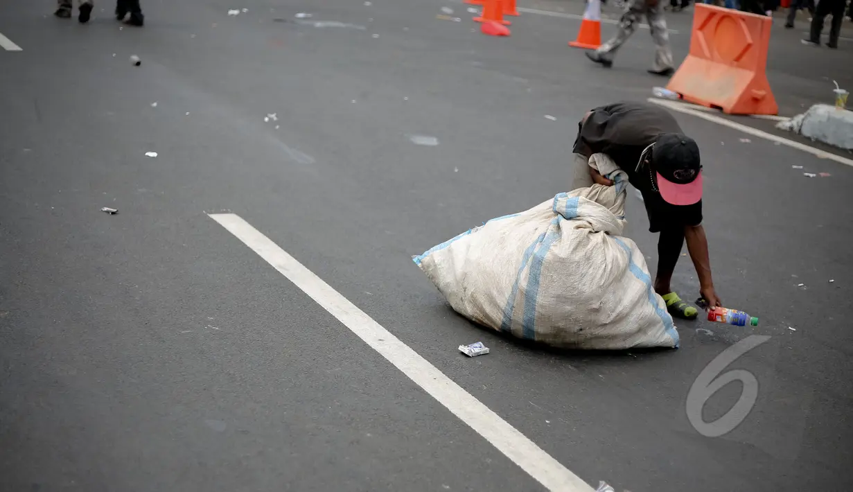 Pemulung memungut botol plastik saat peringatan hari buruh sedunia yang jatuh pada tanggal 1 Mei di depan Istana Merdeka, Jakarta, Jumat (1/5/2015). Aksi demo May Day menyisahkan sejumlah sampah berserakan di jalan. (Liputan6.com/Faizal Fanani)