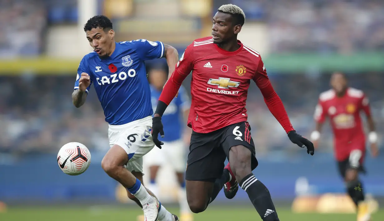 Gelandang Manchester United, Paul Pogba, berebut bola dengan gelandang Everton, Allan, pada laga lanjutan Liga Inggris di Goodison Park Stadium, Sabtu (7/11/2020) malam WIB. Manchester United menang 3-1 atas Everton. (Clive Brunskill/Pool via AP)