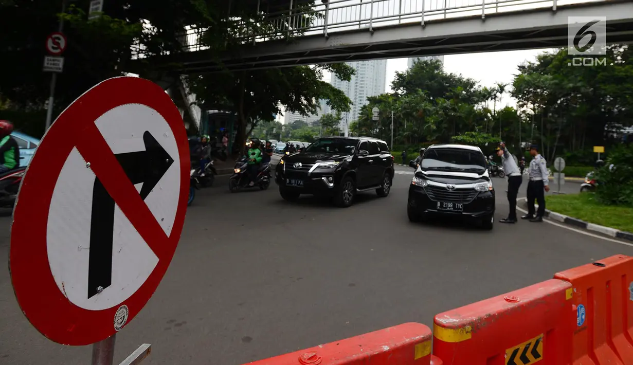 Petugas memberikan penjelasan kepada pengendara mobil saat uji coba sistem satu arah di kawasan Dukuh Bawah, Jakarta, Rabu (13/2). Penataan rekayasa lalu lintas itu guna kemudahan akses pengintegrasian transportasi publik. (Merdeka.com/Imam Buhori)