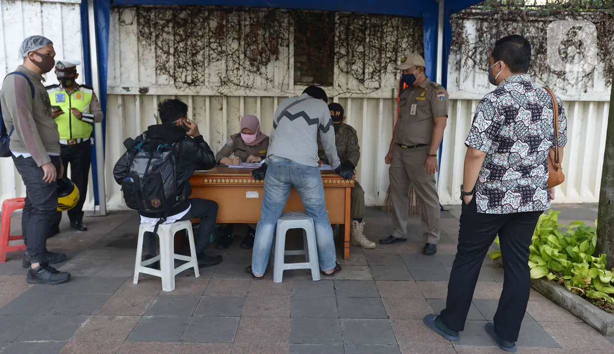 Pelanggar terjaring razia saat Operasi Yustisi Protokol COVID-19 di Kawasan Bundaran HI, Jakarta, Selasa (15/9/2020). Operasi Yustisi itu untuk menegakkan pemakaian masker guna menekan perilaku warga yang memicu angka kenaikan infeksi Covid-19. (merdeka.com/Imam Buhori)