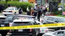 Pihak berwenang berada di pintu masuk gedung setelah penembakan di kantor surat kabar Capital Gazette di Annapolis, AS, Kamis (28/6). Insiden penembakan terjadi ketika staf redaksi sedang melakukan rapat sore hari. (AP/Jose Luis Magana)