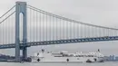 Kapal Rumah Sakit Angkatan Laut USNS Comfort lewat di bawah Jembatan Verrazzano-Narrows dalam perjalanan ke New York, Amerika Serikat, Senin (30/3/2020). Kapal ini memiliki 1.000 tempat tidur dan 12 kamar operasi. (AP Photo/Bebeto Matthews)