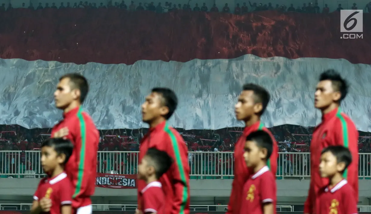 Suporter membentangkan bendera raksasa jelang menyaksikan laga Indonesia U-23 melawan Bahrain pada PSSI Anniversary 2018 di Stadion Pakansari, Kab Bogor, Jumat (27/4). Indonesia kalah 0-1. (Liputan6.com/Helmi Fithriansyah)