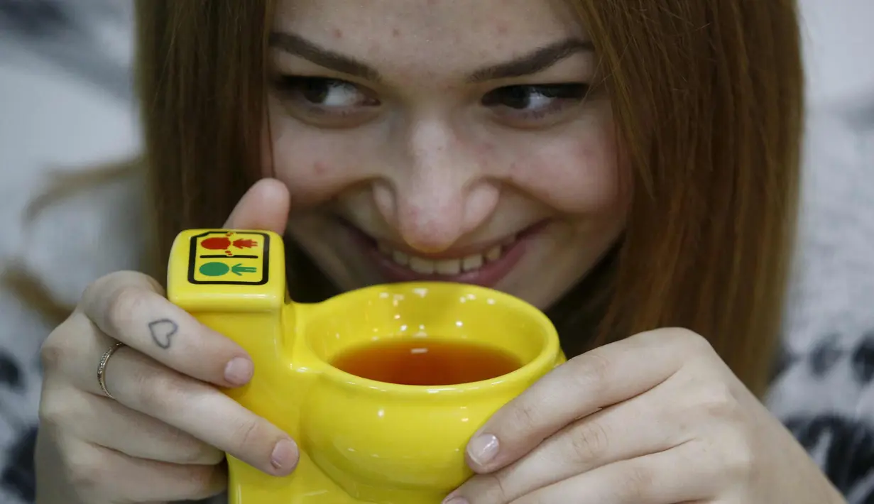 Seorang wanita menikmati minuman di Kafe Crazy Toilet di pusat kota Moskow, Rusia (30/10/2015). Cafe ini memiliki tema interior menyerupai toilet dan menyajikan peralatan seperti yang ada di kamar mandi kecil. (REUTERS/Sergei Karpukhin)